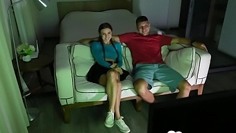A Young Brunette Woman Performs Oral Sex On A Man'S Penis While Sitting On A Couch.